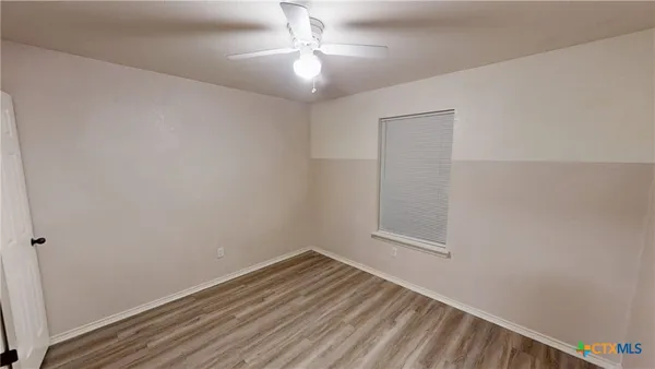 an empty room with a chandelier fan