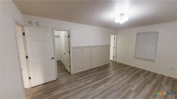 a view of empty room with wooden floor