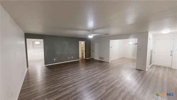 a view of an empty room with wooden floor