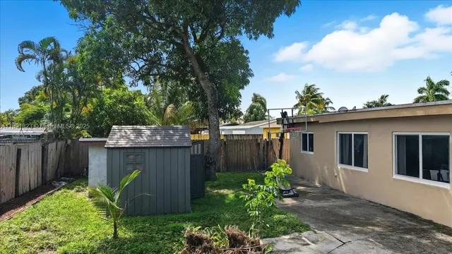 a view of a house with potted plants and a tree