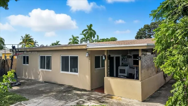 an aerial view of a house with a yard and a large tree