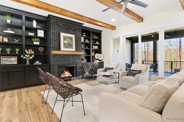 a living room with furniture a fireplace and a floor to ceiling window