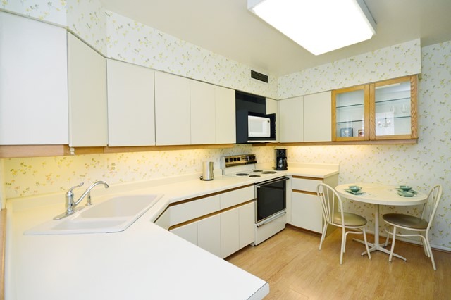 1616 Sheridan Road, Unit 4H Wilmette, IL 60091 - Photo 7 of 16 a kitchen with a sink chairs and white appliances