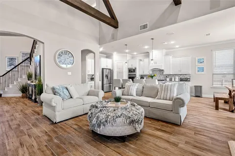 a living room with furniture white walls and wooden floor