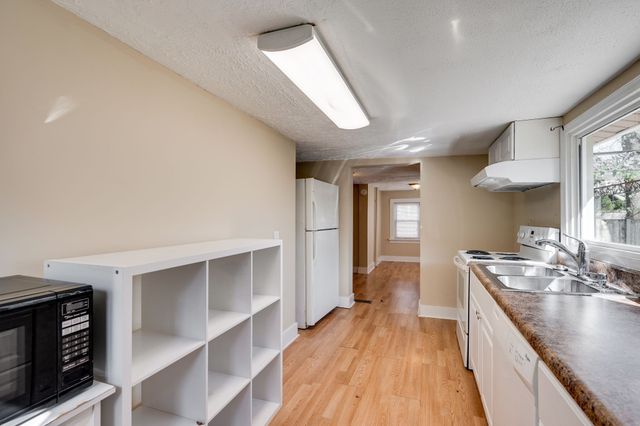 a large kitchen with kitchen island a large counter space a sink appliances and cabinets
