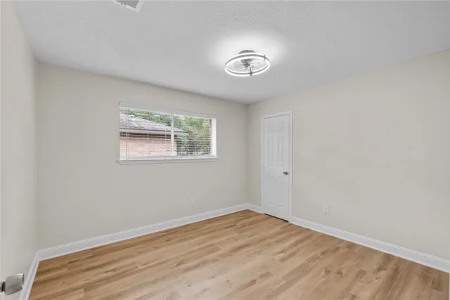 a view of a room that has wooden floor and window