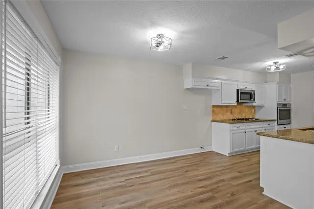 a kitchen with a refrigerator and a stove top oven