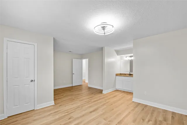 a view of empty room with wooden floor