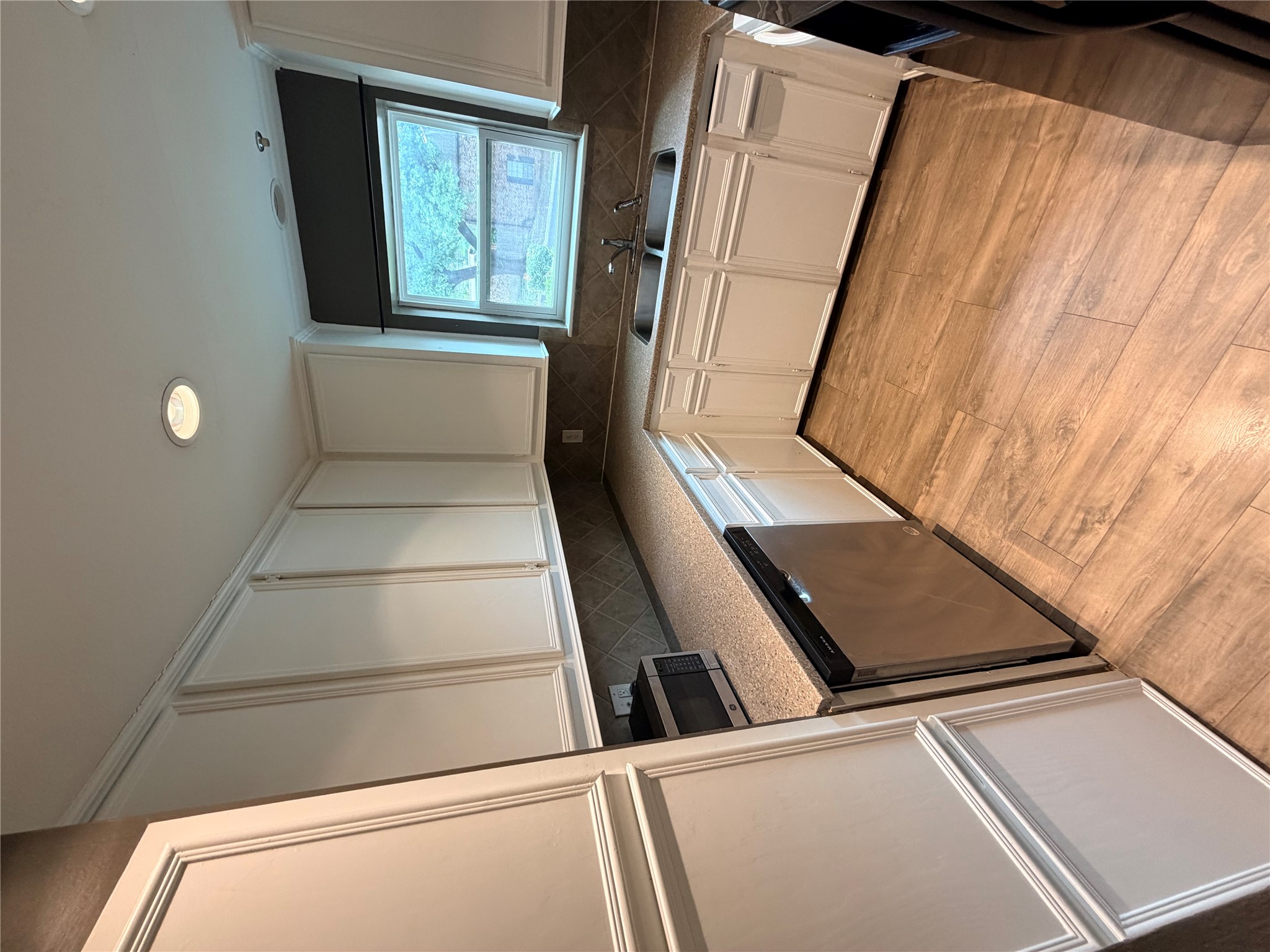 6600 Valleyside Road, Unit D20 Austin, TX 78731 - Photo 13 of 14 Well-equipped culinary space boasts ample white cabinetry and durable wood-look flooring.