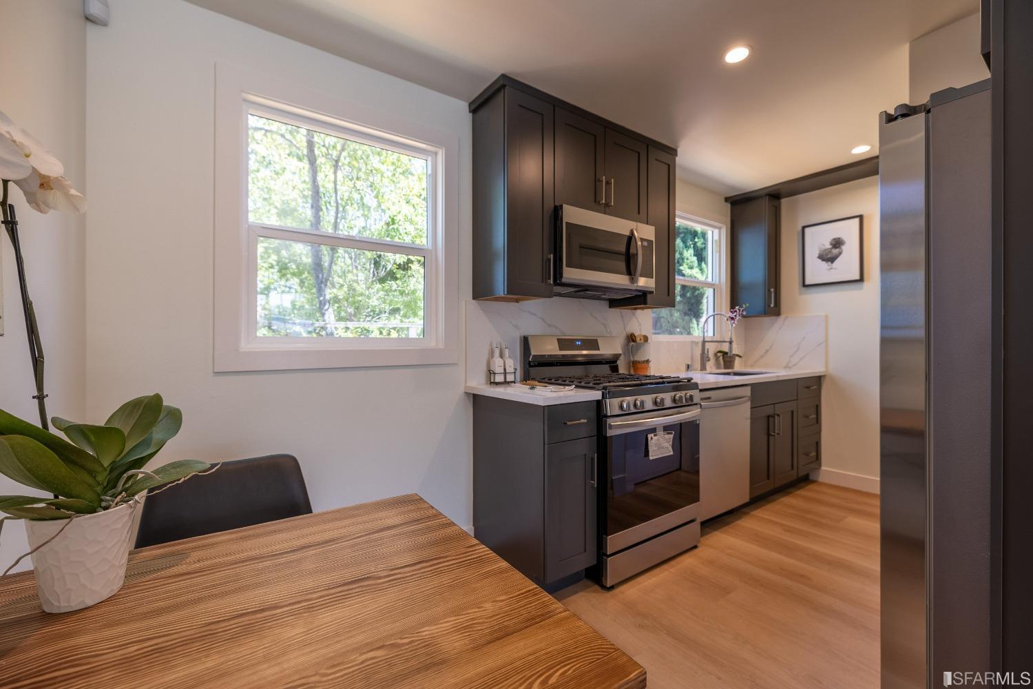 951 University Avenue Berkeley, CA 94710 - Photo 15 of 34 a kitchen with stainless steel appliances kitchen island granite countertop a stove a sink and a microwave