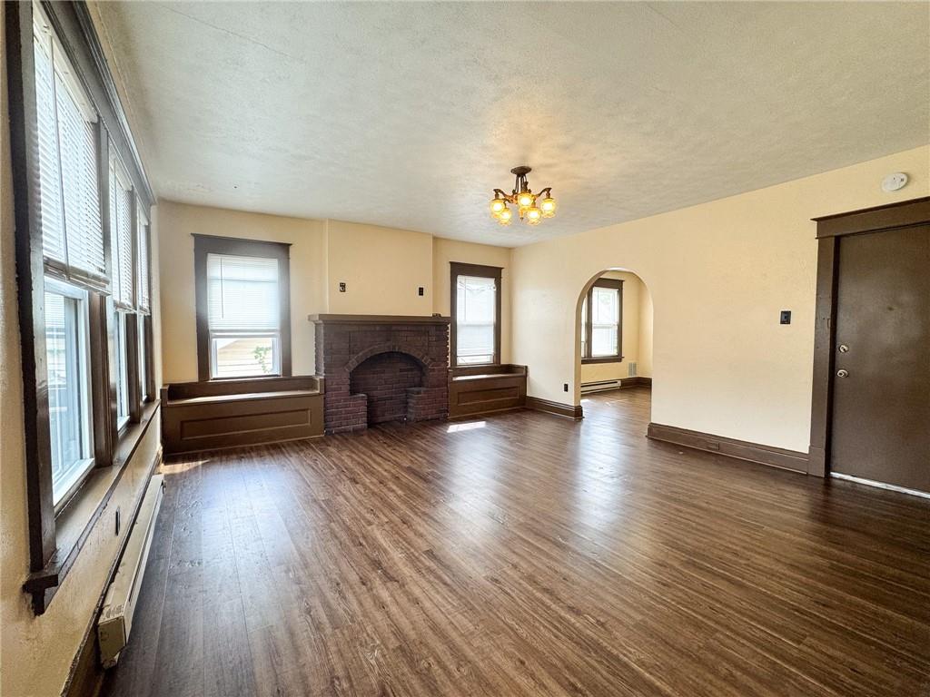 811 Wilmington Road, Unit 6 New Castle, PA 16101 - Photo 3 of 16 an empty room with wooden floor and fireplace