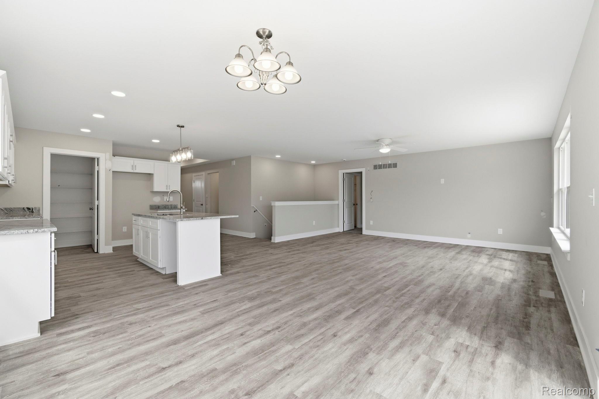 2281 Baltimore Davison, MI 48423 - Photo 10 of 26 Kitchen with white cabinetry, hanging lights, a center island with sink, and light stone countertops
