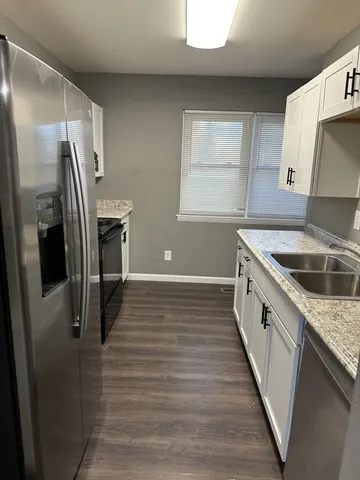 a kitchen with granite countertop a refrigerator and a sink