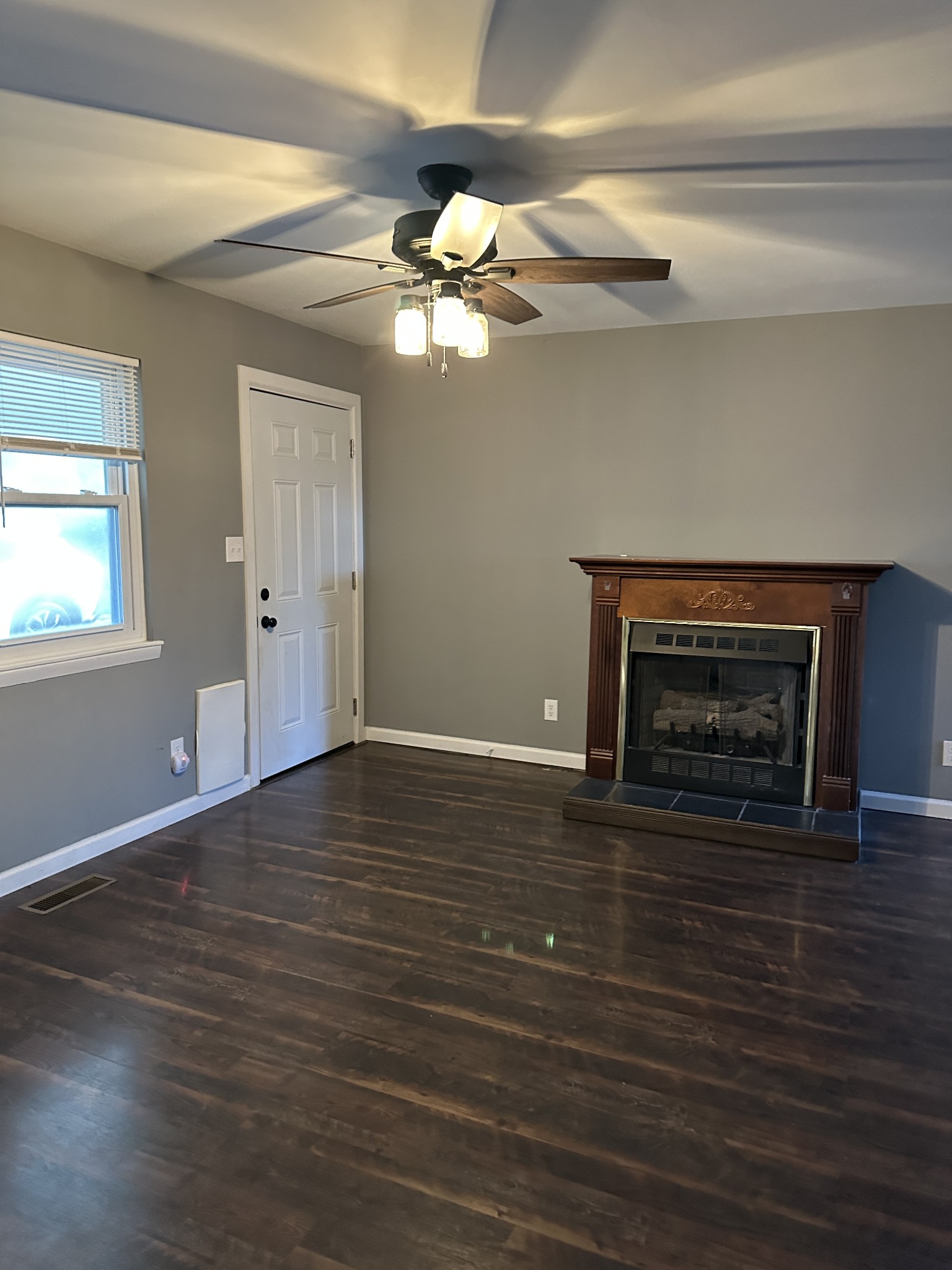 69 Hasty Hollow Road Lynchburg, TN 37352 - Photo 14 of 20 a view of an empty room with wooden floor fireplace and a window