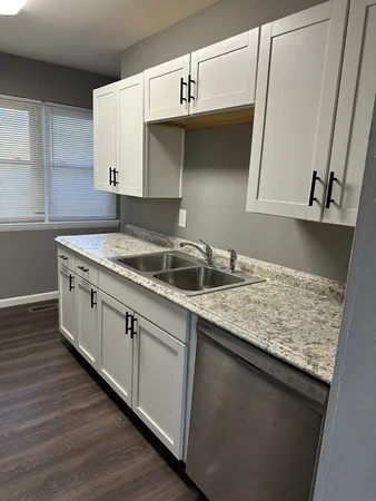 a kitchen with granite countertop a sink and cabinets