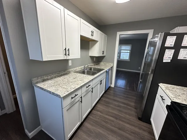 a kitchen with stove cabinets and wooden floor