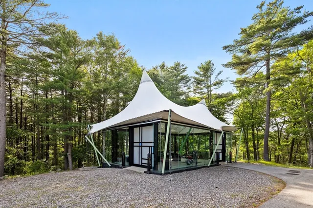 a view of a barn with a small yard and large trees