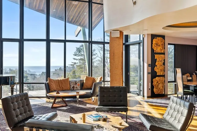 a living room with furniture and floor to ceiling windows