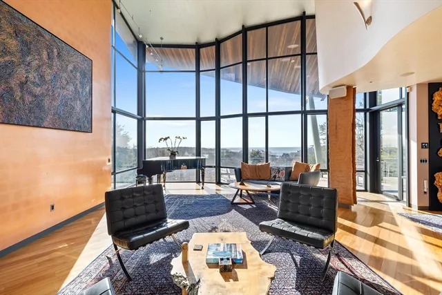 a living room with furniture a rug and a floor to ceiling window