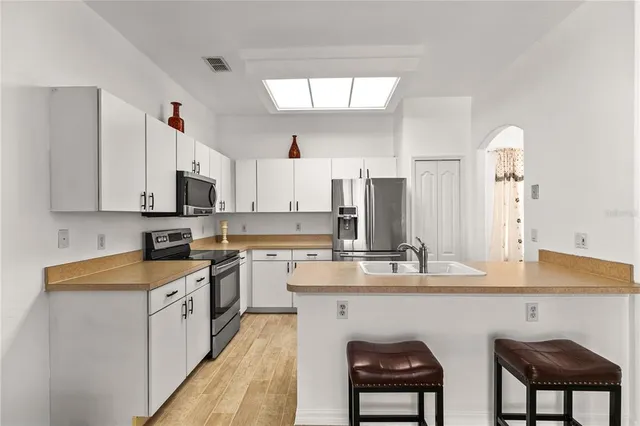 a kitchen with stainless steel appliances a sink stove and cabinets