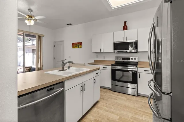 a kitchen with stainless steel appliances a sink stove and refrigerator