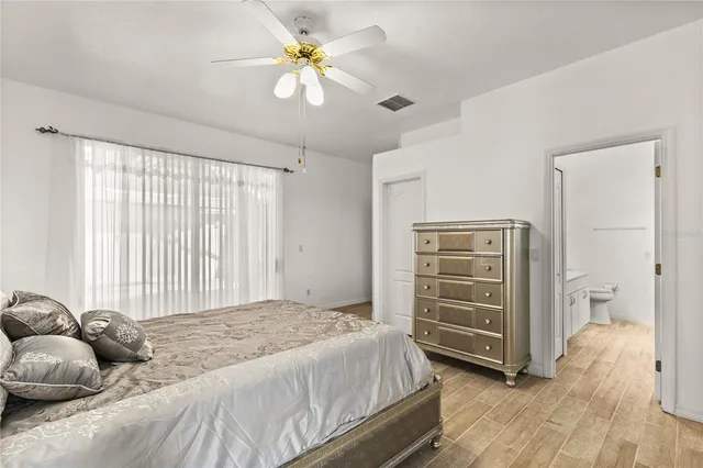 a bedroom with a bed and a ceiling fan