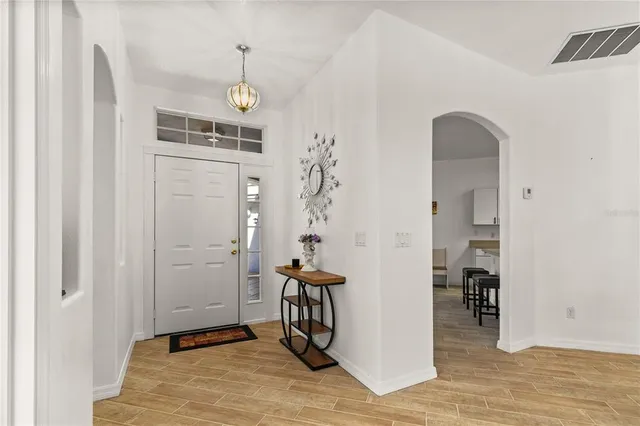 a view of a hallway with wooden floor and entryway