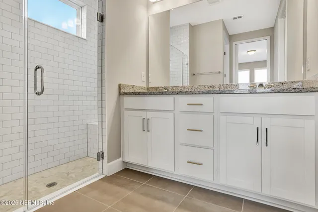 a bathroom with a granite countertop sink and mirror