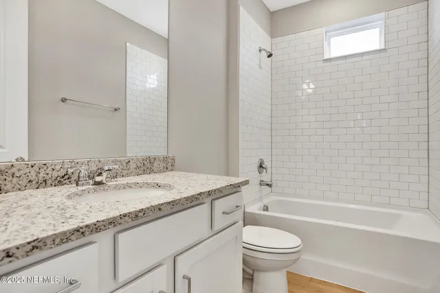 a bathroom with a granite countertop sink a toilet and a bathtub