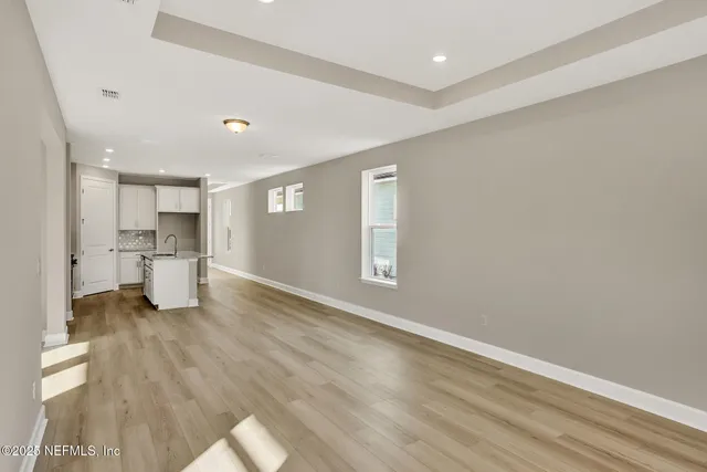 a view of a kitchen with a sink and wooden floor