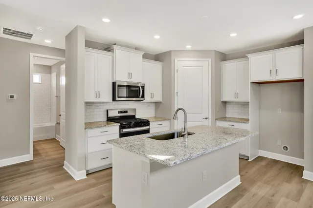 a kitchen with sink a microwave and cabinets