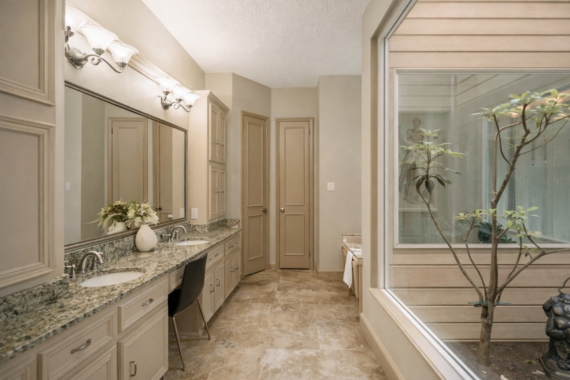 1306 Riverview Court Houston, TX 77077 - Photo 28 of 43 a spacious bathroom with a granite countertop sink a mirror and a shower