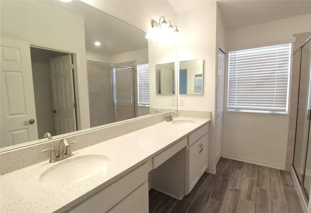 a bathroom with a granite countertop sink and a large mirror