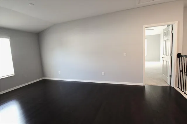 a view of a small space with wooden floor and a window