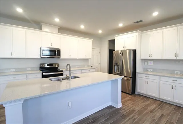 a kitchen with stainless steel appliances a refrigerator sink and microwave