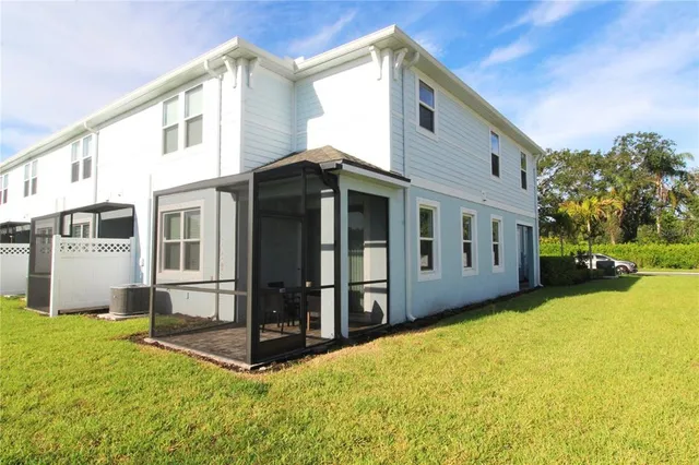 a view of a house with backyard and tree