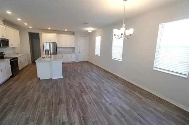 a view of kitchen and hall with wooden floor