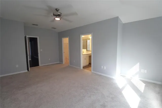 a view of a room with a ceiling fan and window