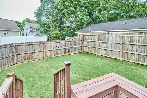 a view of backyard with a small cabin and wooden fence