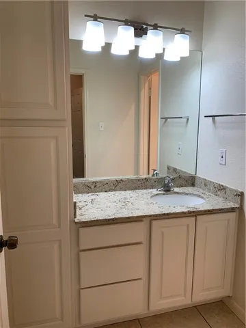 a bathroom with a granite countertop sink and a mirror