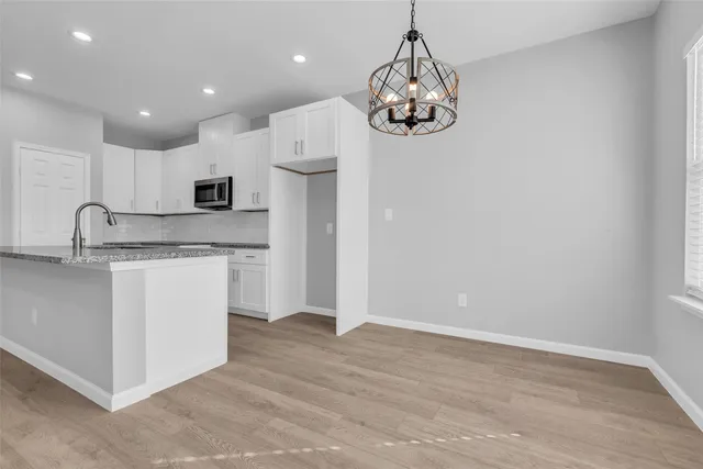 a kitchen with kitchen island granite countertop stainless steel appliances a microwave a stove and a refrigerator