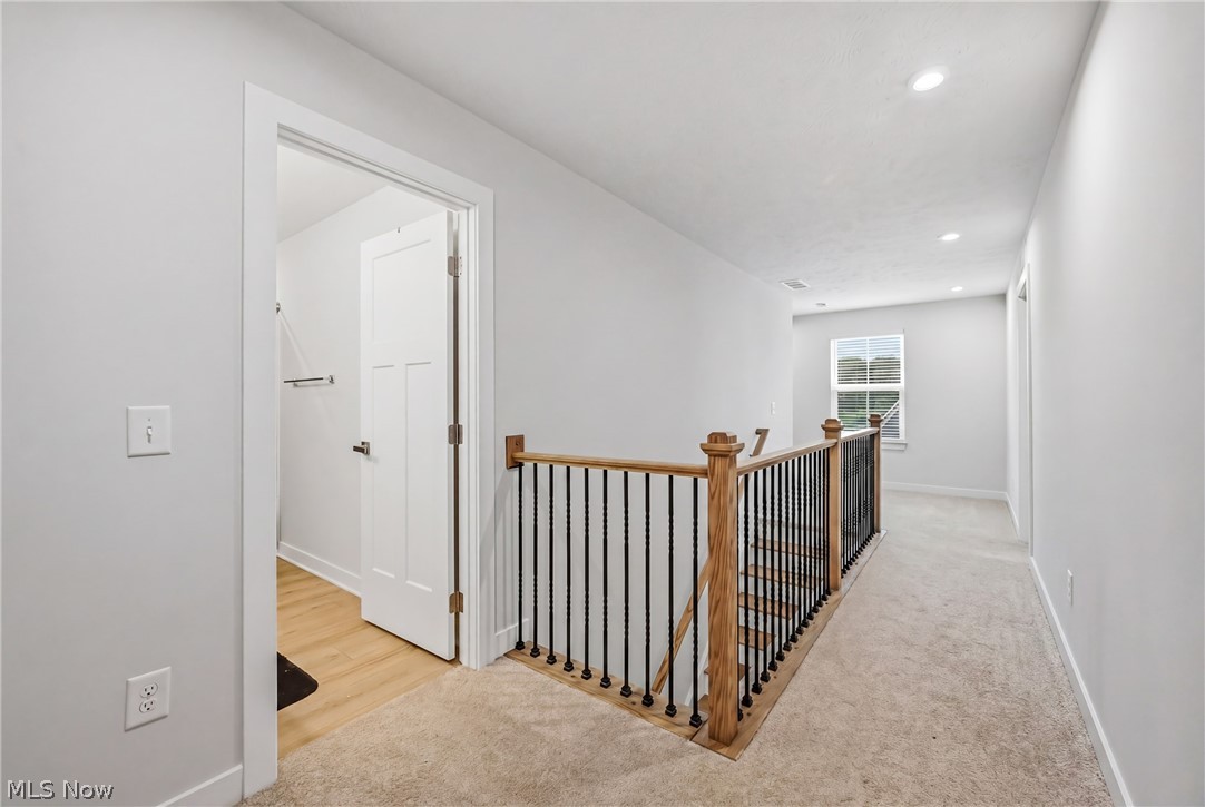 5358 Walnut Rdg Lane Sheffield Lake, OH 44054 - Photo 21 of 50 Upper-level hallway featuring a stairwell with natural wood handrails and black metal balusters