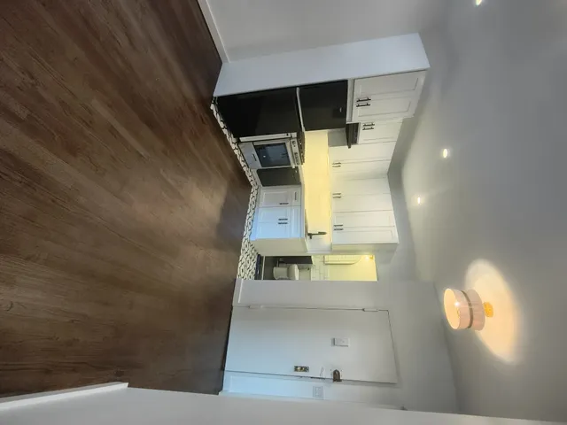 a view of an empty room with a rug and a window