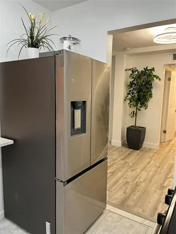 a kitchen with stainless steel appliances a refrigerator and a potted plant