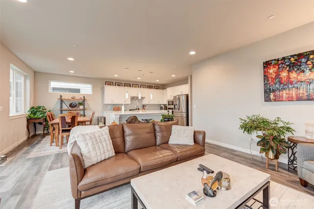 a living room with furniture kitchen and a potted plant