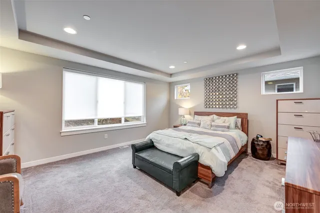 a spacious bedroom with a bed a couch and large window