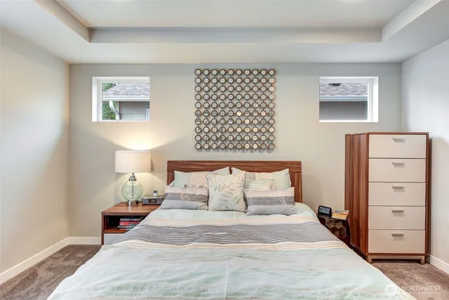 a bedroom with a bed and a lamp on dresser