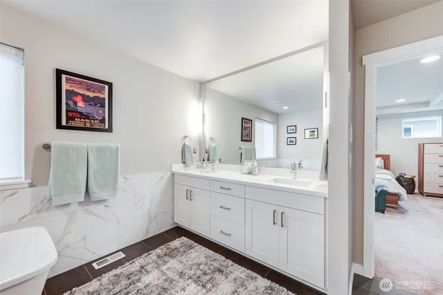 a en suite bathroom with a double vanity sink and a mirror