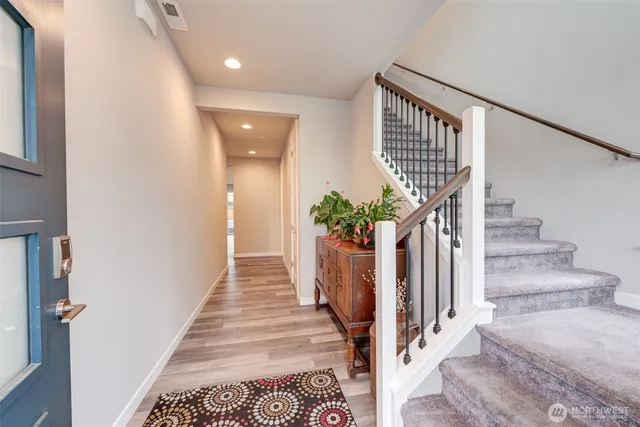 a view of a hallway with wooden floor and a potted plant