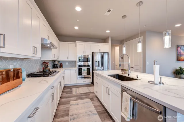a kitchen with stainless steel appliances granite countertop a sink and cabinets